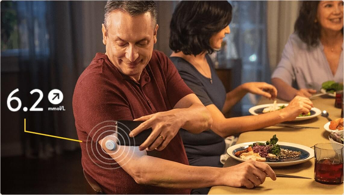 Man using FreeStyle Libre at dinner table